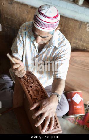 Kaschmiri-Handwerker poliert am 26. Juni 2010 in einer kleinen schwimmenden Werkstatt am Dal Lake in Srinagar, Kaschmir, Indien, eine handgeschnitzte Nussbaumschublade. (Foto von Creative Touch Imaging Ltd./NurPhoto) Stockfoto