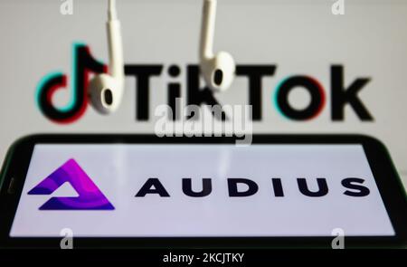Das Audius-Logo auf einem Telefonbildschirm, das TikTok-Logo auf einem Computerbildschirm und Kopfhörer sind auf dieser Illustration zu sehen, die am 17. August 2021 in Krakau, Polen, aufgenommen wurde. (Foto von Jakub Porzycki/NurPhoto) Stockfoto