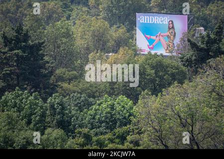 Am 17. August 2021 hing ein leichter Dunst der Luftverschmutzung über Mexiko-Stadt, Mexiko, und verdunkelt die städtische Landschaft und die vielen Wolkenkratzer der Stadt. Oben erhebt sich eine Plakatwand für die Marke Andrea über dem Wald von Chapultepec. (Foto von Diego Cupolo/NurPhoto) Stockfoto