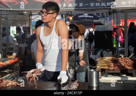 Am 24. Juli 2015 barbiert der Lebensmittelhändler auf einem Stock Tintenfisch während eines ganztägigen chinesischen Marktes in Markham, Ontario, Kanada. (Foto von Creative Touch Imaging Ltd./NurPhoto) Stockfoto