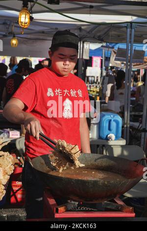 Der Lebensmittelhändler fritiert am 24. Juli 2015 auf einem chinesischen Markt in Markham (Ontario, Kanada) „quid Lutscher“ (große gebratene Tintenfische, die mit einem Teig auf einem Stock bedeckt sind) in einem großen Wok, der mit kochendem Öl gefüllt ist. (Foto von Creative Touch Imaging Ltd./NurPhoto) Stockfoto