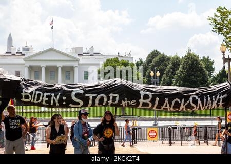 Eine schwarze Schlange, die Ölpipelines symbolisiert, kommt im Weißen Haus während eines Protests gegen Enbridges Linie 3-Pipeline an, die von Shut Down DC und Extinction Rebellion gesponsert wird. Die Pipeline verläuft durch Vertragsgebiete und das Quellgebiet des Mississippi River, um Ölsand aus Kanada zu transportieren. Seine ökologischen und klimatischen Auswirkungen in den nächsten 50 Jahren werden mit dem Bau und Betrieb von 50 Kohlekraftwerken, dem Weißen Haus am 23. August 2021 in Washington DC, USA, vergleichbar sein. (Foto von Allison Bailey/NurPhoto) Stockfoto