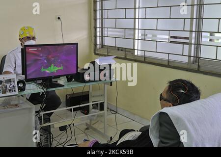 Ein psychiatrischer Rehabilitationspatient während einer Neurofeedback-Therapie am 25. August 2021 im Marzoeki Mahdi Hospital in Bogor, West Java, Indonesien. Die Neurofeedback-Therapie ist eine Heiltherapie für psychiatrische Rehabilitationspatienten, indem sie Spiele über einen Computerbildschirm spielt, der direkt bewegt wird, um die Fähigkeiten von Gehirnwellen zu messen. (Foto von Adriana Adie/NurPhoto) Stockfoto