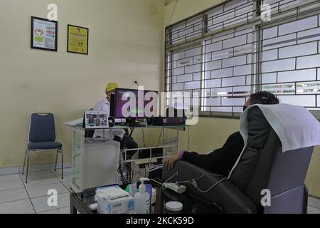 Ein psychiatrischer Rehabilitationspatient während einer Neurofeedback-Therapie am 25. August 2021 im Marzoeki Mahdi Hospital in Bogor, West Java, Indonesien. Die Neurofeedback-Therapie ist eine Heiltherapie für psychiatrische Rehabilitationspatienten, indem sie Spiele über einen Computerbildschirm spielt, der direkt bewegt wird, um die Fähigkeiten von Gehirnwellen zu messen. (Foto von Adriana Adie/NurPhoto) Stockfoto