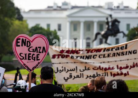 Ein CODEPINK-Demonstrator hält ein Zeichen, das Israel auffordert, den Angriff auf Gaza während eines Protestes gegen Naftali Bennetts ersten Besuch im Weißen Haus als Premierminister Israels zu beenden. Die Demonstranten fordern, dass die Vereinigten Staaten Israel für seine fortgesetzten Angriffe auf Palästinenser, einschließlich der Tötung von Kindern und der fortgesetzten Entfernung von Palästinensern aus ihren Häusern, sanktionieren. Als die Kundgebung begann, informierten Beamte des Geheimdienstes die Demonstranten, dass sie im Lafayette Park nicht protestieren könnten und richteten eine Polizeilinie um den Umkreis auf. Der Befehl ist sehr ungewöhnlich; der Geheimdienst erlaubt es regelmäßig Stockfoto