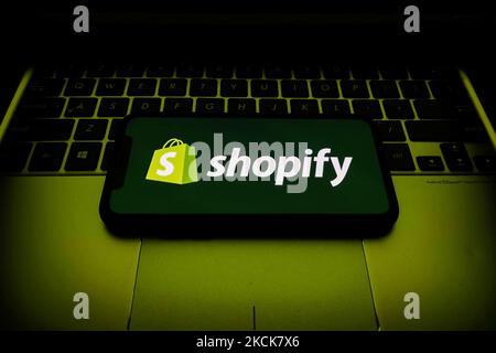 Das Shopify-Logo, das auf einem Telefonbildschirm und einer Laptop-Tastatur angezeigt wird, ist auf diesem Bild zu sehen, das am 26. August 2021 in Krakau, Polen, aufgenommen wurde. (Foto von Jakub Porzycki/NurPhoto) Stockfoto