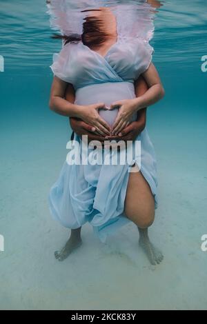 Das junge Paar posiert für eine Unterwasserfotositzung. Stockfoto