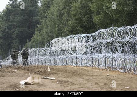 Am 27. August 2021 werden Soldaten der polnischen Armee in der Nähe der weißrussischen Grenze in Krynki, Polen, einen Zaun mit Konzertsagewand bauen sehen. Polen baut einen 100 Kilometer langen Zaun, um dem Zustrom von Migranten aus Belarus Einhalt zu Gebieten. Im Monat August haben mehr als 2000 Migranten die Grenze nach Polen überschritten, im Vergleich zu nur rund 80 im letzten Jahr. Dem Lukaschenko-Regime wird vorgeworfen, die Ankunft von Tausenden von Migranten aus dem Nahen Osten als Vergeltung für EU-Sanktionen zu inszenieren. (Foto von STR/NurPhoto) Stockfoto