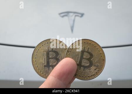 Illustrative Abbildung von zwei Gedenkbitcoins, die vor dem Tesla Model X Auto zu sehen sind. Donnerstag, 26. August 2021, in Edmonton, Alberta, Kanada. (Foto von Artur Widak/NurPhoto) Stockfoto