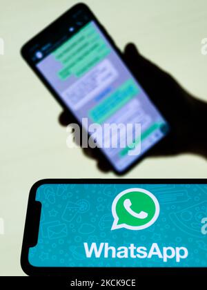 Das WhatsApp-Logo, das auf einem Telefonbildschirm angezeigt wird, und die Unterhaltung auf dem WhatsApp-Bildschirm im Hintergrund sind auf diesem Illustrationsfoto zu sehen, das am 27. August 2021 in Krakau, Polen, aufgenommen wurde. (Fotoillustration von Jakub Porzycki/NurPhoto) Stockfoto
