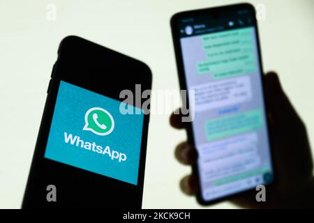 Das WhatsApp-Logo, das auf einem Telefonbildschirm angezeigt wird, und die Unterhaltung auf dem WhatsApp-Bildschirm im Hintergrund sind auf diesem Illustrationsfoto zu sehen, das am 27. August 2021 in Krakau, Polen, aufgenommen wurde. (Fotoillustration von Jakub Porzycki/NurPhoto) Stockfoto