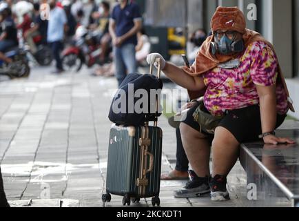 Ein Tourist, der eine Gasmaske und sein Gepäck trug, während eines Protestkampfes mit Bereitschaftspolizisten bei der Demonstration am 29. August 2021 in Bangkok. Demonstranten fordern, dass Thailands Premierminister Prayut Chan-o-cha zurücktritt und die Regierung für ihr grobes Missmanagement der Covid-19-Pandemie zur Verantwortung gezogen wird. (Foto von Chaiwat Subprasom/NurPhoto) Stockfoto