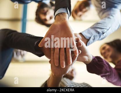 Sie haben einen praktischen Ansatz für das Geschäft. Eine Aufnahme eines Teams von Geschäftsleuten, die sich im Büro die Hände übereinander stapeln. Stockfoto