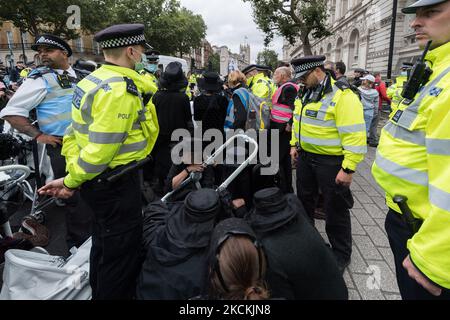 LONDON, VEREINIGTES KÖNIGREICH - 31. AUGUST 2021: Aktivisten des Extinction Rebellion blockieren den Eingang zur Downing Street während eines trauermarsches, in dem die britische Regierung am 31. August 2021 in London, England, einen sofortigen Stopp aller Investitionen in fossile Brennstoffe forderte. Die Aktion ist Teil der „Unmöglichen Rebellion“, einer neuen Welle von Protesten und zivilen Ungehorsamsmaßnahmen, die sich an Regierungen und Finanzinstitutionen richten. (Foto von Wiktor Szymanowicz/NurPhoto) Stockfoto