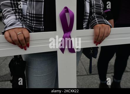 Ein Aktivist hält am International Overdosure Awareness Day auf der Capital Plaza vor dem Federal Building ein weißes Kreuz mit violettem Band, um auf die Zahl der Menschen aufmerksam zu machen, die täglich an Überdosen sterben. Am Dienstag, den 31. August 2021, Kanada. (Foto von Artur Widak/NurPhoto) Stockfoto