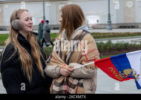 Moskau, Russland. 4.. November, 2022 Menschen winken russische Fahnen während eines Flashmob "Wir sind vereint" am Haupteingang des VDNKh Ausstellungszentrums und Park am Tag der Nationalen Einheit Russlands, in Moskau, Russland Stockfoto