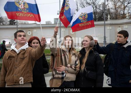 Moskau, Russland. 4.. November, 2022 Menschen winken russische Fahnen während eines Flashmob "Wir sind vereint" am Haupteingang des VDNKh Ausstellungszentrums und Park am Tag der Nationalen Einheit Russlands, in Moskau, Russland Stockfoto