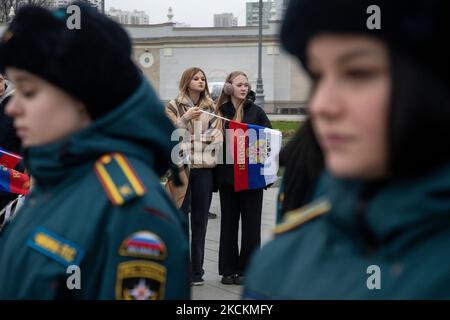 Moskau, Russland. 4.. November, 2022 Menschen winken russische Fahnen während eines Flashmob "Wir sind vereint" am Haupteingang des VDNKh Ausstellungszentrums und Park am Tag der Nationalen Einheit Russlands, in Moskau, Russland Stockfoto