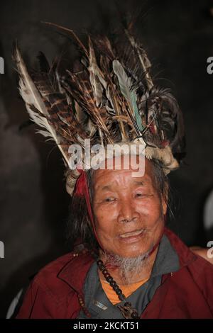 Ein 90-jähriger Lepcha-Bomthing (Lepcha-Priester), der einen gefiederten Hut trägt, singt am 05. Juni 2010 während einer Tieropferzeremonie in einem kleinen Dorf tief im Dschungel in Sikkim, Indien, Gebete, um böse Geister zu besänftigen. Viele Dorfbewohner sind ohne jegliche Unterstützung gestorben, deshalb haben die Dörfer von Lepcha die Bombe geschickt, um die bösen Geister zu beseitigen, die im Dorf zu Tode kamen. Diese Zeremonie soll das Dorf 180 Jahre lang schützen, nachdem es vorgeformt wurde. (Foto von Creative Touch Imaging Ltd./NurPhoto) Stockfoto