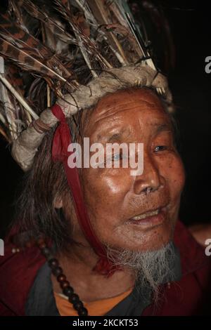 Ein 90-jähriger Lepcha-Bomthing (Lepcha-Priester), der einen gefiederten Hut trägt, singt am 05. Juni 2010 während einer Tieropferzeremonie in einem kleinen Dorf tief im Dschungel in Sikkim, Indien, Gebete, um böse Geister zu besänftigen. Viele Dorfbewohner sind ohne jegliche Unterstützung gestorben, deshalb haben die Dörfer von Lepcha die Bombe geschickt, um die bösen Geister zu beseitigen, die im Dorf zu Tode kamen. Diese Zeremonie soll das Dorf 180 Jahre lang schützen, nachdem es vorgeformt wurde. (Foto von Creative Touch Imaging Ltd./NurPhoto) Stockfoto