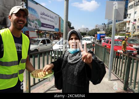 Am 6. September 2021, nachdem sechs palästinensische Gefangene am Montag, den 6. September 2021, aus dem Gilboa-Gefängnis in Nordisrael geflohen waren, gibt ein Palästinenser Süßigkeiten auf der Straße in Gaza-Stadt aus. Israelische Streitkräfte starteten am Montag eine massive Menschenjagd im Norden Israels und im besetzten Westjordanland, nachdem die Gefangenen in einem äußerst seltenen Ausbruch über Nacht aus der Hochsicherheitseinrichtung entkommen waren. (Foto von Majdi Fathi/NurPhoto) Stockfoto