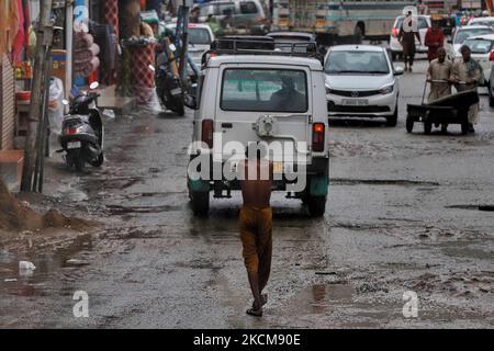 Ein obdachloser Mann ohne Kleidung läuft am 11. September 2021 inmitten von Regenfällen in der Nähe von Bus Stand baramulla, Jammu und Kaschmir, Indien. Der Autoverkehr wurde durch den Erdrutsch auf dem Srinagar-Jammu Highway unterbrochen. (Foto von Nasir Kachroo/NurPhoto) Stockfoto