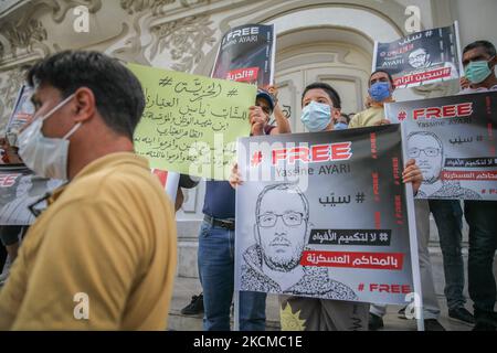 Yassine Ayaris Sohn (C) hält ein Plakat mit der Aufschrift ‘Free Yassine Ayari’ auf englisch und ein weiteres Plakat mit der Aufschrift auf Arabisch ‘ Nein, um den Mund von Militärgerichten zu murren ‘, während einer Demonstration in Tunis, Tunesien, am 11. September 2021, Die Freilassung der unabhängigen tunesischen Abgeordneten Yassine Ayari zu fordern, Nachdem er Facebook-Beiträge veröffentlicht hatte, die dem Militär kritisch gegenüberstanden, wurde er verhaftet und zu zwei Monaten Gefängnis verurteilt, weil er im Jahr 2018 am Militärberufungsgericht wegen „Teilnahme an einem Akt zur Zerstörung der Moral der Armee“ verurteilt wurde. (Foto b Stockfoto