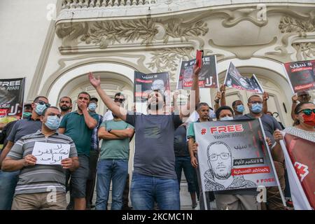 Demonstranten halten Plakate von Yassine Ayari mit der Aufschrift ‘frei Yassine Ayari, als ein Protestler während einer Demonstration in Tunis, Tunesien, am 11. September 2021, eine Kopie der tunesischen Verfassung mit Gesten und Slogans aufruft, um die Freilassung der unabhängigen tunesischen Abgeordneten Yassine Ayari zu fordern, Nachdem er Facebook-Beiträge veröffentlicht hatte, die dem Militär kritisch gegenüberstanden, wurde er verhaftet und zu zwei Monaten Gefängnis verurteilt, weil er im Jahr 2018 am Militärberufungsgericht wegen „Teilnahme an einem Akt zur Zerstörung der Moral der Armee“ verurteilt wurde. (Foto von Chedly Stockfoto