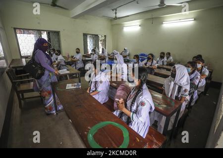 Am 12. September 2021 besuchen die Schüler ihre Klasse an der Tejgaon Government Girls' High School in Dhaka, als die Schulen in Bangladesch nach 18 Monaten nach einer der weltweit längsten Stillstandszeiten aufgrund der Coronavirus-Pandemie Covid-19 wieder eröffnet wurden. Die Wiederaufnahme erfolgte, nachdem UNICEF davor gewarnt hatte, dass die anhaltenden Schulschließungen während der Covid-19-Krise die Ungleichheiten für Millionen von Kindern in ganz Südasien verschärfen würden. (Foto von Ahmed Salahuddin/NurPhoto) Stockfoto