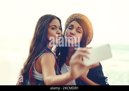 Ihr Selfie-Spiel ist auf dem Punkt. Zwei junge Freunde nehmen ein Selfie zusammen im Freien. Stockfoto