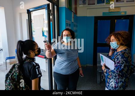 Ein scholastischer Mitarbeiter des Höheren Instituts Mons. Antonio Bello in Molfetta misst die Temperatur der Schüler am ersten Schultag in Molfetta, Italien, am 14. September 2021. Gestaffelte Einweisungen, Doppelschichten, obligatorische Green Pass für Schulpersonal, Eltern in der Klasse nur mit Pass, flexiblere Entfernungen in der Klasse. Am 13. September begann die Rückkehr in die Klasse für 3,9 Millionen Schüler aus zehn Regionen des Landes, während die anderen 3,5 Millionen Schüler das neue Schuljahr versetzt nach regionalen Kalendern beginnen werden, bis zum 20. September (die letzten Apulien und Kalabrien). Die dritte Stockfoto