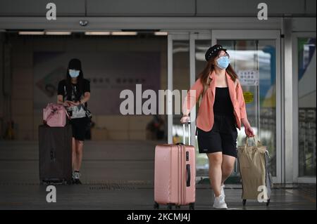 Personen mit Gepäck gehen durch die Türen des Shenzhen Bay Immigration Control Point in Hongkong, 15. September 2021. Hongkong hat angekündigt, ab heute nicht-Hongkonger Bürger aus China ohne Quarantäne nach Hongkong einreisen zu lassen, Hongkong hat im Vergleich zum Rest der Welt die strengste Quarantänemaßnahme verhängt. (Foto von Vernon Yuen/NurPhoto) Stockfoto