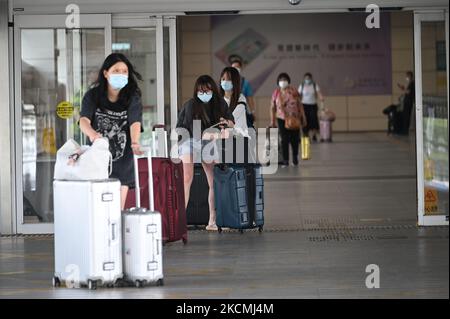 Personen mit Gepäck gehen durch die Türen des Shenzhen Bay Immigration Control Point in Hongkong, 15. September 2021. Hongkong hat angekündigt, ab heute nicht-Hongkonger Bürger aus China ohne Quarantäne nach Hongkong einreisen zu lassen, Hongkong hat im Vergleich zum Rest der Welt die strengste Quarantänemaßnahme verhängt. (Foto von Vernon Yuen/NurPhoto) Stockfoto