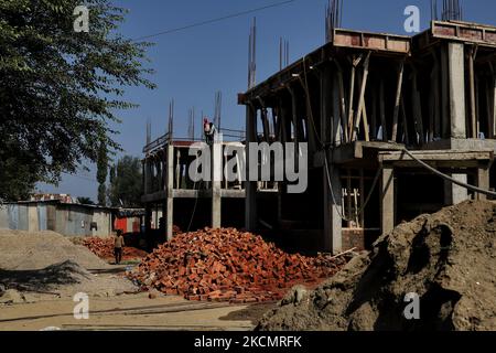 Am 18. September 2021 arbeiten nicht-lokale Arbeiter in der Kolonie pandit in Baramulla, Jammu und Kaschmir, Indien. Im Rahmen der Bemühungen, sie im Kaschmir-Tal zu rehabilitieren, wird hier ein Transitlager mit 40 â‚¹ errichtet, in dem 336 Migrantenfamilien aus Kashmiri Pandit untergebracht werden sollen, sagte Unionsministerin Sarbananda Sonowal am Freitag. Nachdem er den Grundstein für das Transitlager gelegt hatte, sagte er, dass dies ein sehr wichtiger Schritt der Zentralregierung für die Migrantenfamilien Kashmiri Pandit sei, die zurückkehren und friedlich in Kaschmir leben wollen. „Für die Rehabilitation der Kashmiri-Pandits, ein tr Stockfoto