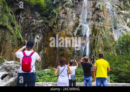 Touristen beobachten am 15. September 2021 den Großen Wasserfall (Veliki Slap) im Nationalpark Plitvicer Seen in Kroatien. Im Jahr 1979 wurde der Nationalpark Plitvicer Seen aufgrund seiner herausragenden und malerischen Reihe von Tuffenseen und Höhlen, die durch Wasserfälle miteinander verbunden sind, in die UNESCO-Liste des Weltkulturerbes aufgenommen. (Foto von Beata Zawrzel/NurPhoto) Stockfoto