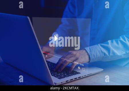Geschäftsmann streamt Live-Videos für Inhalte online mit einem Notebook (Laptop) im Wohnzimmer. Streamer mit Kopfhörern Sprechen Sie mit dem Hörpublikum. Neu Stockfoto