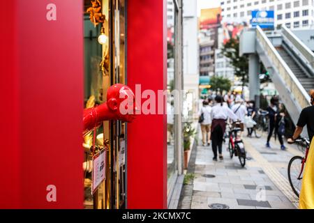05/09/2021 Tokio, Japan. Eine menschliche Skulptur reicht bis an die Außenseite einer Kunstgalerie, um die wenigen Käufer anzuziehen, die durch das Zentrum Tokios laufen. Der Covid-Notstand in Japan hält an und die Touristenorte und Bürobereiche sind viel weniger frequentiert. Obwohl die Fälle von Coronaviren allmählich zurückgehen, versucht die Regierung, über die Verlängerung des Ausnahmezustands COVID-19 in Tokio und anderen Ballungsgebieten zu entscheiden, in denen Krankenhäuser weiterhin unter Druck stehen. (Foto von Mauro Ujetto/NurPhoto) Stockfoto