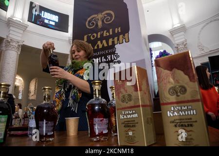 Moskau, Russland. Am 4.. November 2022 Bietet Eine Frau den armenischen Vintage-Cognac „Berge und Steine“ beim Wein- und Spirituosenfest „Armwinefest 2022“ im Armenischen Pavillon im VDNH in Moskau, Russland, an Stockfoto