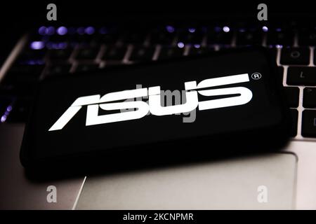 Das Asus-Logo, das auf einem Telefonbildschirm und einer Laptop-Tastatur angezeigt wird, ist auf diesem Bild zu sehen, das am 30. September 2021 in Krakau, Polen, aufgenommen wurde. (Foto von Jakub Porzycki/NurPhoto) Stockfoto