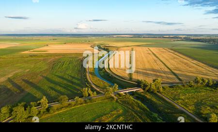 Draufsicht auf die Landschaft, landwirtschaftliche Felder, Fluss und Straßenbrücke über den Fluss Stockfoto