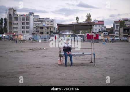 Ein iranischer Mann mit einer schützenden Gesichtsmaske sitzt auf einer Bank an einem Ufer des Kaspischen Meeres in der Stadt Anzali, 366 km (227 Meilen) nördlich von Teheran, inmitten des Ausbruchs der neuen Coronavirus-Krankheit (COVID-19) im Iran, September 27, 2021. Die Stadt Anzali ist wegen der neuen Coronavirus-Krankheit immer noch rot markiert, während die anderen Städte der Provinz Gilan, Lahijan und Rasht, in die Farbe Orange gewechselt sind und sich in einem besseren Zustand befinden. (Foto von Morteza Nikoubazl/NurPhoto) Stockfoto