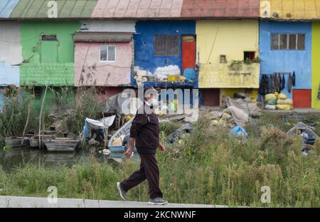 Ein iranischer Mann mit einer schützenden Gesichtsmaske geht an einem Flussufer entlang, um den farbenfrohen Basar des Fischers in der Hafenstadt Anzali, 366 km (227 Meilen) nördlich von Teheran, am 28. September 2021 zu sehen. Der Fisherman’s Basar, auch Samstagsbasar genannt, ist ein 70 Jahre alter Basar, der sich entlang des Flusses in der Mirza-Kuchak-Khan-Straße von Anzali befindet. (Foto von Morteza Nikoubazl/NurPhoto) Stockfoto