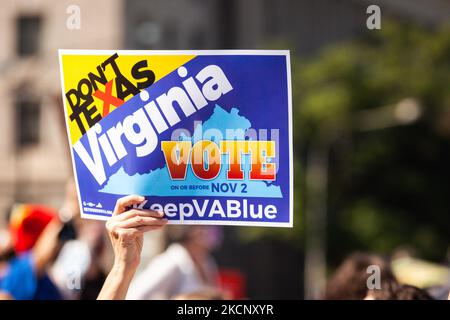 Ein Protestler hält ein Schild, das die Virginier dazu auffordert, während der Marschversammlung der Frauen für Abtreibungsjustiz in Washington, DC, für die Demokratische Partei zu stimmen. Die Wahlen in Virginia im Jahr 2021 werden von vielen als Indikator für die Präferenzen der Wähler bei den Zwischenwahlen im Jahr 2022 angesehen. Die Demonstranten auf dem marsch fordern die US-Regierung, die reproduktiven Rechte von Frauen und den Zugang zu Abtreibungen landesweit zu schützen. Konkret fordern sie den Kongress auf, das Frauengesundheitsschutzgesetz (WHPA) und JEDES Gesetz zu verabschieden, das den Zugang zu Abtreibungen garantiert und eine Versicherung verlangt. Mehr als 600 Satellitenproteste finden nationwi statt Stockfoto