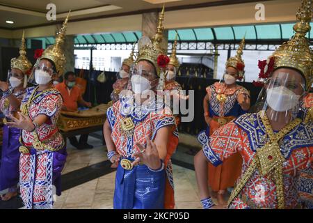 Thailändische Tänzer tragen Gesichtsmasken und schützende Gesichtsschilder während einer Aufführung zur Anbetung von Lord Brahma, dem hinduistischen Gott der Schöpfung, im Erawan-Schrein in Bangkok, Thailand, am 03. Oktober 2021. (Foto von Anusak Laowias/NurPhoto) Stockfoto