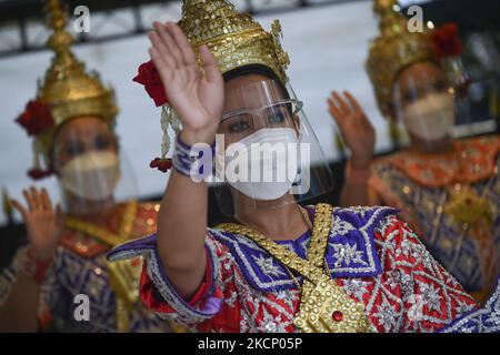 Thailändische Tänzer tragen Gesichtsmasken und schützende Gesichtsschilder während einer Aufführung zur Anbetung von Lord Brahma, dem hinduistischen Gott der Schöpfung, im Erawan-Schrein in Bangkok, Thailand, am 03. Oktober 2021. (Foto von Anusak Laowias/NurPhoto) Stockfoto