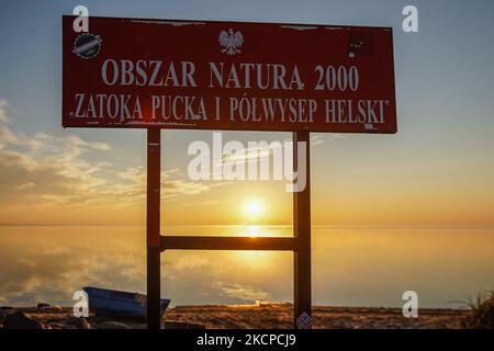 Sonnenaufgang über der Küste des Danziger Golfs (Ostsee) mit einem Natura 2000 (Nature 2000) zatoka Gdanska-Schild im Vordergrund ist am 10. Oktober 2021 in Oslonino, Polen zu sehen (Foto: Michal Fludra/NurPhoto) Stockfoto