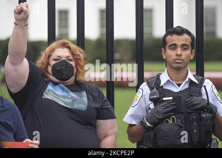 Am 11. Oktober 2021 steht neben einem Polizisten der US-Parkpolizei vor dem Weißen Haus eine mit der Faust erhobene Frau. (Foto von Zach Brien/NurPhoto) Stockfoto