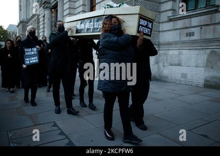 Mitglieder der Aktivistengruppe Global Justice, die sich jetzt dafür einsetzt, dass Pharmaunternehmen Patente auf Covid-19-Impfstoffe aussetzen, tragen am 12. Oktober 2021 während eines „trauermarschs“ vom Parliament Square zur Downing Street in London, England, falsche Särge entlang Whitehall. Global Justice kritisiert nun Großbritannien wegen gegenteiliger Vorschläge für eine Covid-19-Patentaussetzung bei der Welthandelsorganisation. Die Aussetzung von Patenten würde sie behaupten, dass die Welt die Produktion von Covid-19-Impfstoffen ankurren und verhindern würde, dass sich zwischen reichen und armen Ländern ein Zustand der „Impfstoff-Apartheid“ entwickelt. ( Stockfoto