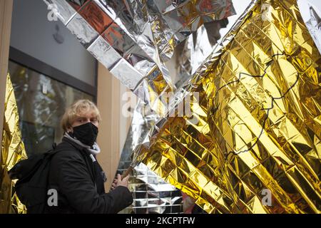 Ein Mann hält während einer Solidaritätsdemonstration mit Flüchtlingen an der polnisch-weißrussischen Grenze in Warschau am 17. Oktober 2021 eine Decke mit einer Fahne. (Foto von Maciej Luczniewski/NurPhoto) Stockfoto