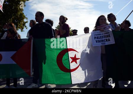 Demonstranten halten Agerian-Fahnen fest. Dutzende von Demonstranten gehen, um den 60.. Jahrestag der Tötung algerischer Demonstranten durch die französische Polizei am 17. 1961. Oktober in Paris zu vermelden. Am 17. 1961. oktober gingen Algerier auf die Straße, um die FLN (Nationale Befreiungsfront) zu unterstützen, die einen Unabhängigkeitskrieg von Frankreich führte. Polizisten intervenierten und töteten mindestens 120 Menschen (durch Ertrinken in der seine oder Erschießen an einem Punkt, an dem nichts schießt). Sie verhafteten mindestens 12.000 Personen und schlugen viele Demonstranten schwer. Noch heute erkennen weder die französische Polizei noch der Staat dieses Massaker an, auch wenn es so ist Stockfoto